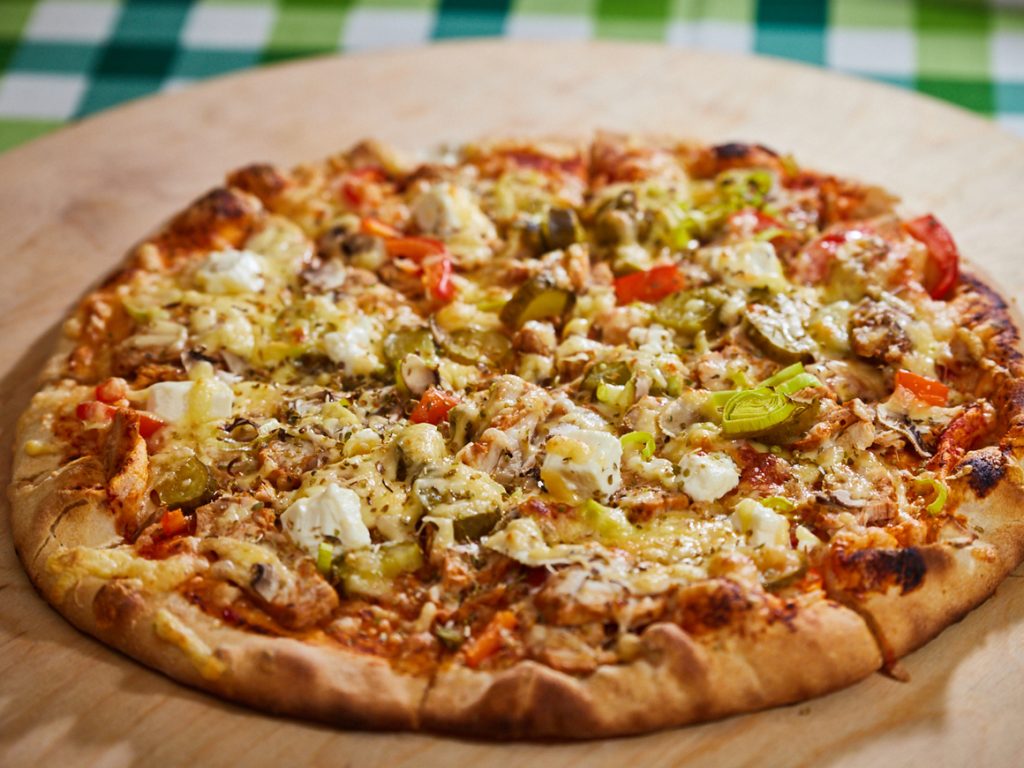 Pizza z serem i dodatkami na drewnianej desce